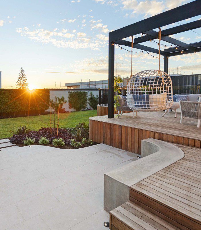 Olivia Limestone set against an elevated timber outdoor entertaining area with a lawn and planting in the background.