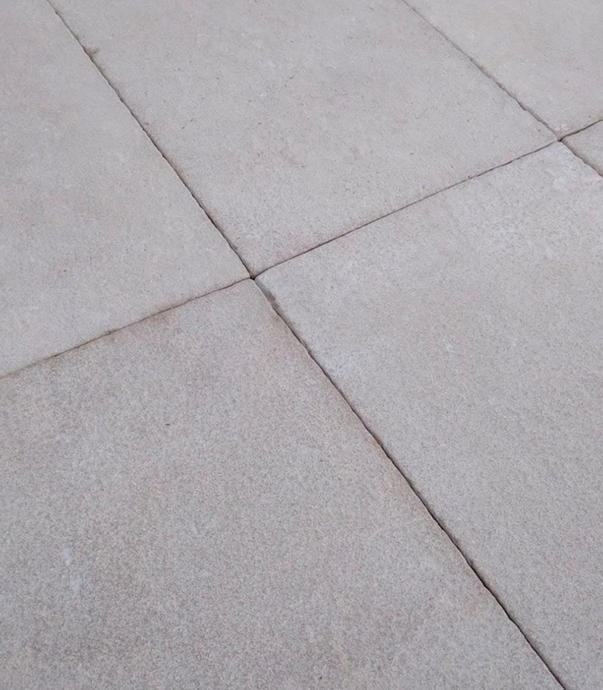 A close-up image of Marshet Limestone pavers. The stone features roasted almond hues and the edges are tumbled.