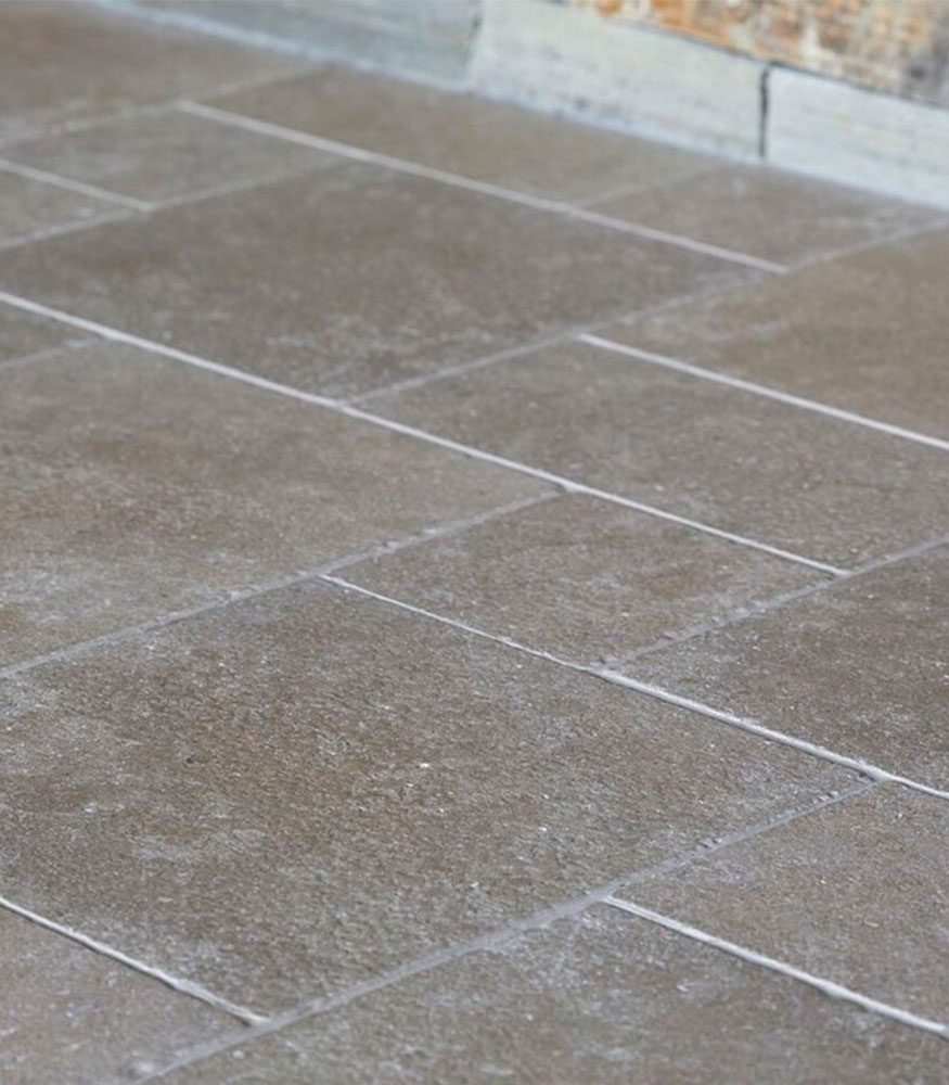 Caramel-coloured limestone pavers. The textured tiles are installed in a French pattern.