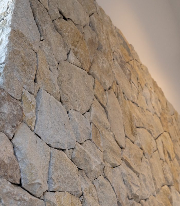 A close-up image of a wall clad with dry-stacked stone. Somerton Irregular Quartz Limestone has the perfect cool-toned majority with speckles of warm tones throughout the stones.